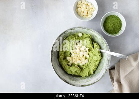 Backhintergrund mit grünem Tee Matcha Teig, Schokolade Chips, Eier Stockfoto