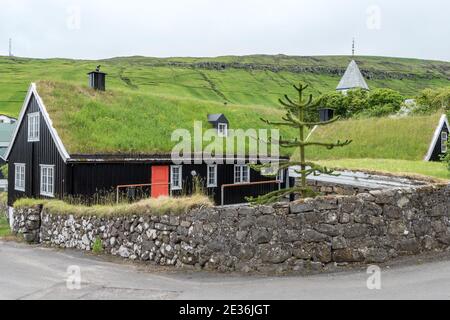 Viking Langhäuser, Grasdach, mit Kirchturm in der Ferne, Kvivik Dorf, Streymoy Insel, Färöer Inseln Stockfoto