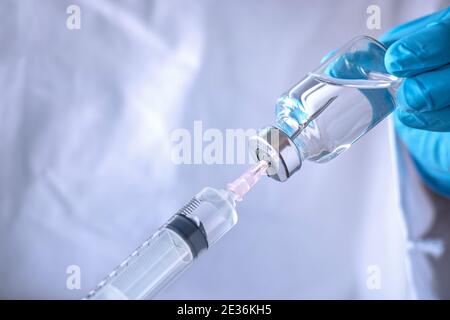 Coronavirus COVID-19 Impfstoffkonzept. Arzt Hand hält Nadel Spritze und Impfstoffflasche für Corona-Virus verhindern Behandlung und Labormedizin Stockfoto