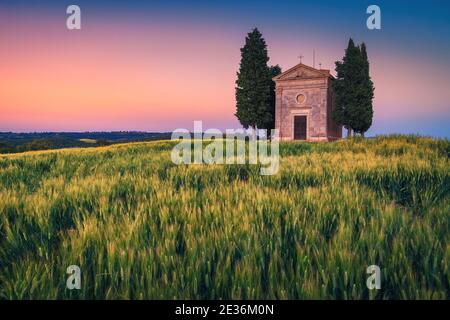 Große Fotografie und touristischen Ort in der Toskana, nette kleine Vitaleta Kapelle im Getreidefeld bei bunten Sonnenuntergang, Pienza, Toskana, Italien, Europa Stockfoto