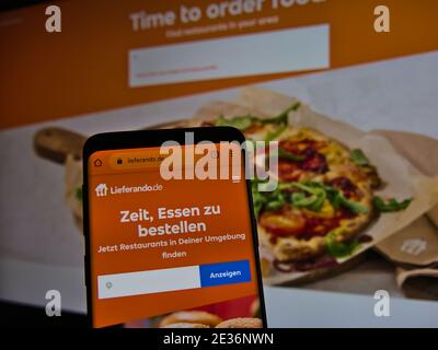 Website des Online-Lebensmittellieferungsunternehmens Lieferando.de auf dem Smartphone angezeigt. Text: Zeit, um Essen zu bestellen. Finden Sie Restaurants in Ihrer Nähe. Stockfoto