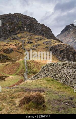 Atemberaubende Winterlandschaft Bild der Ansicht von Side Pike in Richtung Langdale Hechte mit niedrigen Wolken auf Bergspitzen und moody Mist Stockfoto