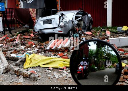 Mamuju, Indonesien. Januar 2021. Nach dem Erdbeben der Stärke 6.2 in Mamuju City, West Sulawesi, passieren die Bewohner das Schutthüllgebiet. (Foto von Zul Kifli/Pacific Press) Quelle: Pacific Press Media Production Corp./Alamy Live News Stockfoto