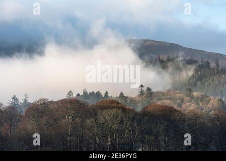 Episches Landschaftsbild mit Blick über Derwentwater im Lake District Catbells schneebedeckter Berg mit dichtem Nebel Rollen durch Tal Stockfoto