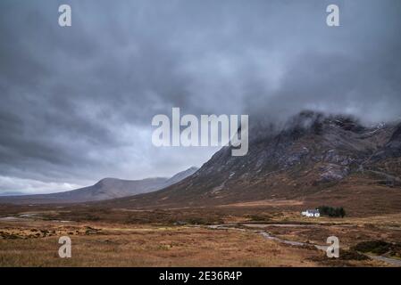 Atemberaubende Landschaftsaufnahme im Glencoe Valley in den schottischen Highlands Mit Bergketten in dramatischer Winterbeleuchtung Stockfoto