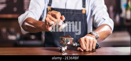 Banner der asiatischen Barista Tamping der Portafilter und Vorbereitung Tasse Kaffee, Espresso mit Latte oder Cappuccino für Kundenauftrag im Café, klein Stockfoto
