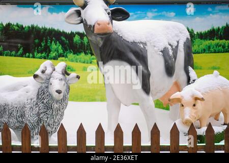 Kuh-, Schwein- und Widderstatuen auf dem Hof. Figuren von Nutztieren im Schnee im Winter auf dem Hintergrund der Sommer Natur - Moskau, Russland, 06. Januar 2 Stockfoto