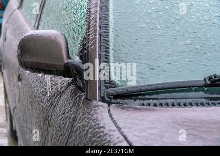 Eisiger Rückspiegel, Windschutzscheibe, Auto mit Eiszapfen, Eis aus nächster Nähe. Gefrorenes Auto Stockfoto