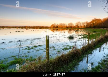Frühmorgens Sonnenlicht über einem überfluteten Feld in England Stockfoto