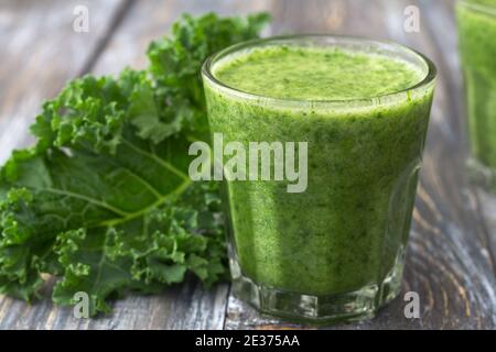 Grüne Smoothies mit Grünkohl, Banane und Zitrone. Auf einem Holztisch. Selektiver Fokus. Gesunde Ernährung Stockfoto