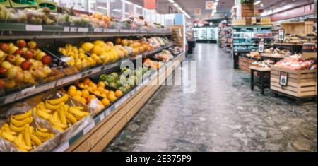 Voll ausgestattete Gänge in einem Lebensmittelgeschäft. Verschiedene Obst- und Gemüsesorten auf Regalen im Supermarkt. Stockfoto