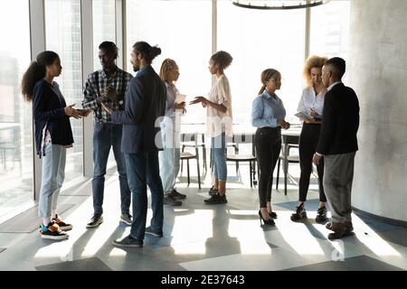 Bei zwanglosen Büromeeting sprechen verschiedene Kollegen in Gruppen Stockfoto