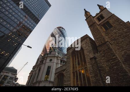 London, Großbritannien - 7. Juli 2017: Die moderne Stadtarchitektur des 30 St. Mary AX Building (The Gherkin) und der historischen St. Helen's Church, Bishopsgate in Lon Stockfoto