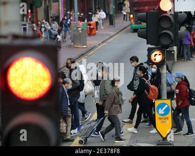 Hongkong, China. Januar 2021. Menschen mit Gesichtsmasken gehen über eine Straße in Hongkong, Südchina, 17. Januar 2021. Das Zentrum für Gesundheitsschutz in Hongkong (CHP) meldete am Sonntag 55 weitere bestätigte Fälle von COVID-19, insgesamt 9,557. Die neuen Fälle umfassten 51 lokale Infektionen, von denen 16 einen unbekannten Ursprung hatten, so eine CHP-Pressekonferenz. Es gab auch mehr als 80 Fälle, die vorläufig positiv getestet wurden. Quelle: Li Gang/Xinhua/Alamy Live News Stockfoto