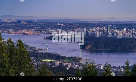 Panoramablick auf die Stadtlandschaft von Vancouver, einschließlich der architektonischen Wahrzeichen Lions Gate Bridge und der Gebäude in der Innenstadt in der Abenddämmerung, British Columbia, Kanada. Stockfoto