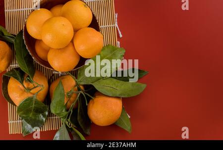 Mandarine orange mit grünem Blatt mit Korb isoliert auf Roter Hintergrund Stockfoto