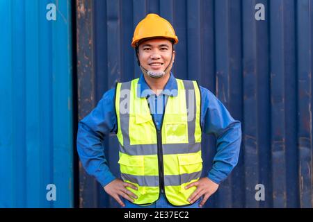 Portrait der asiatischen Arbeiter Import und Export Waren Tragen Sie einen Helm logitics Versand auf Container Hintergrund. Stockfoto