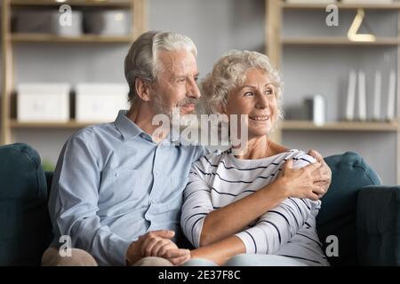 Ein verträumtes Familienpaar mittleren Alters, das sich auf dem Sofa entspannt. Stockfoto