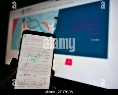 Person mit Smartphone mit Aktienkurskursen des deutschen Pharma- und Life-Sciences-Unternehmens Bayer AG. Konzentrieren Sie sich auf die Mitte des Handybildschirms. Stockfoto