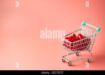 Warenkorb voller Herzen zum Valentinstag auf rosa Hintergrund Stockfoto