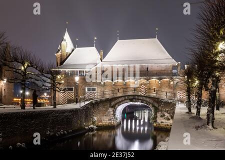 Der historische Koppelpoort in Amersfoort, Niederlande, ist im Winter mit Schnee bedeckt. Das Gebäude ist ein altes und mittelalterliches Wassertor zum holländischen CI Stockfoto