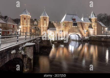 Der historische Koppelpoort in Amersfoort, Niederlande, ist im Winter mit Schnee bedeckt. Das Gebäude ist ein altes und mittelalterliches Wassertor zum holländischen CI Stockfoto