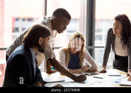 Konzentriertes gemischtes Rennen diverse Kollegen entwickeln Marketingstrategie im Büro. Stockfoto