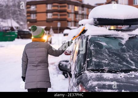 Moskau. Russland. Winter 2020. Der Fahrer räumt dem Auto Schnee. Bei starkem Schneefall in Moskau. Stockfoto