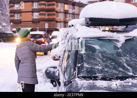 Moskau. Russland. Winter 2020. Der Fahrer räumt dem Auto Schnee. Bei starkem Schneefall in Moskau. Stockfoto