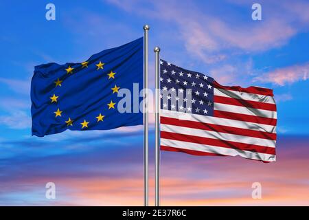 Beziehungen zwischen den USA und der Europäischen Union. Zwei Flaggen von Ländern am Himmel mit Sonnenuntergang. 3D-Darstellung. Stockfoto