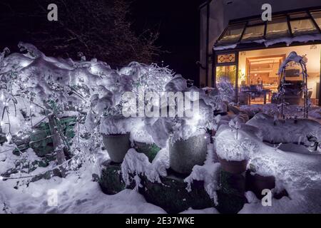 Nächtlicher Schnee und funkelnde LED-Abendlichter erleuchten die Yorkshire kleinbäuerliche Bauernhaus Stockfoto