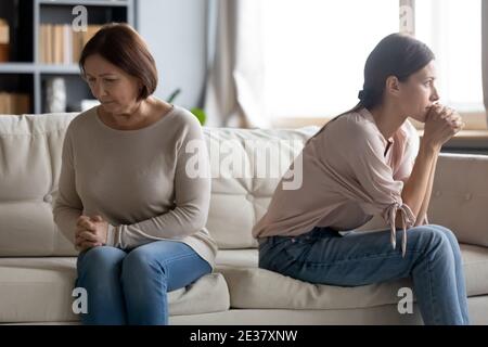 Unglückliche junge Frau und reife Mutter vermeiden zu reden nach Streit Stockfoto