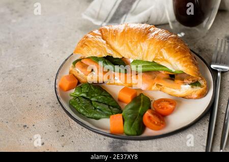 Croissant-Sandwich mit Quark, Lachs, Spinat. Gesundes Frühstück Stockfoto