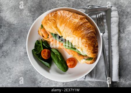 Croissant-Sandwich mit Quark, Lachs, Spinat. Gesundes Frühstück. Draufsicht, Kopierbereich. Stockfoto