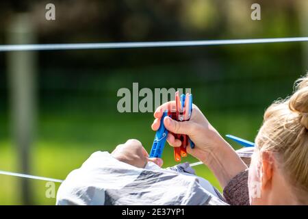 Bunte Wäscheklammer Wäscheklammern am Seil. Bunte Stoffclips in einem Seil warten auf die nächste Charge von Kleidung nach der Wäsche kommen. Stockfoto