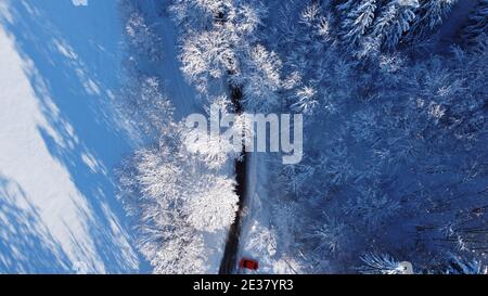 Luftdrohne Aufnahme von Straße mit verschneiten Landschaft und rot Auto Stockfoto