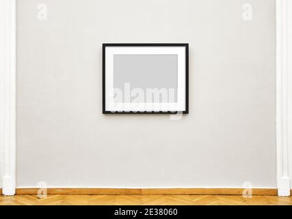 Schwarzer leerer Bilderrahmen, der an der Ausstellungswand hängt, Vorderansicht der Museumsexposition Stockfoto