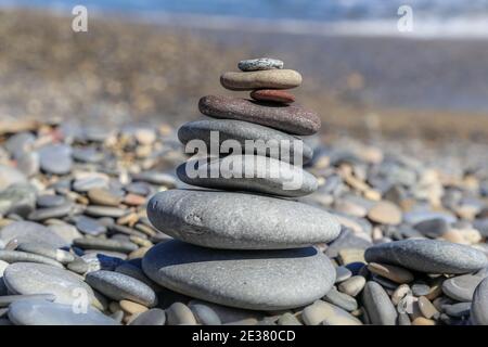 Selektive Fokus von bunten Steinen wie eine Pyramide, die gestapelt Hat sich zu einem regelmäßigen Anblick an lokalen Stränden Zentrum von Konzentrieren Sie sich auf einen Strand Stockfoto