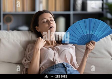 Nahaufnahme erschöpft überhitzte Frau winken Papierventilator zu Hause Stockfoto