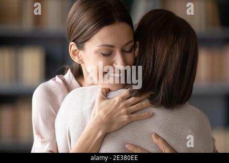 Nahaufnahme liebevolle lächelnde junge Frau umarmt reife Mutter Stockfoto