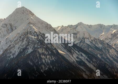 Schmelzender Schnee offenbart die Textur des Berges mit Bäumen Beginn nach dem Winter zu zeigen Stockfoto