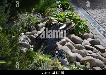 Skulptur Frosch mit einem Buch im Park. Bronzedenkmal eines großen Frosches, ein Buch lesend, und kleine Frösche um ihn herum. Charkiw, Ukraine 6. september 2020: Stockfoto