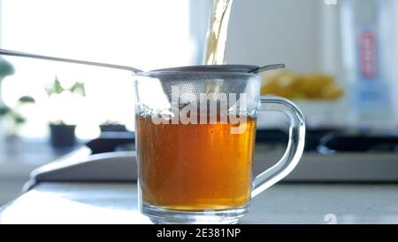 Bild mit der Herstellung eines heißen und aromatischen Tee mit einem Sieb und natürliche Tee Leafs Stockfoto