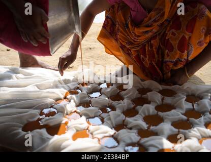 Familienmitglieder von palmsaftsammlern machen im Dorf Mohanbhog aus palmsaft Zacken. Agartala, Tripura, Indien. Stockfoto