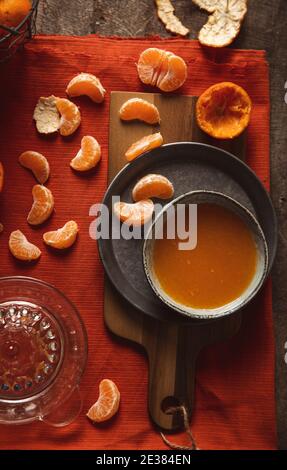 Frisch gepresste Mandarinensaft im Glas auf rustikalen Holzmöbeln Hintergrund Stockfoto