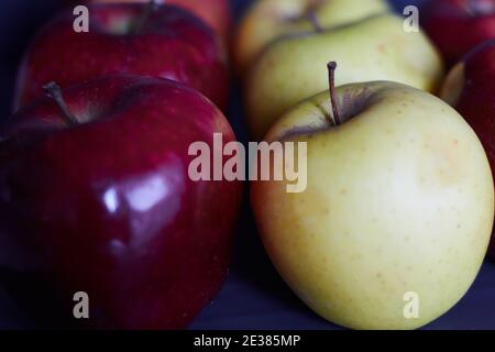 Mehrere leuchtend rote Äpfel und grüne Äpfel. Nahaufnahme von roten und grünen Äpfeln. Rote und grüne Äpfel in einer Reihe. Stockfoto