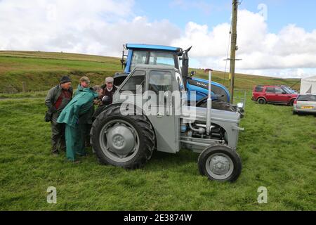 Muirkiirk, East Ayrshire, Schottland, Großbritannien, Village landwirtschaftliche Show, lokale Bauern und ihre Familien treffen und konkurrieren mit Vieh, Schafe & Rinder auf dem DisplayEine Gruppe von Bauern bewundern die Traktoren alt und neu Stockfoto