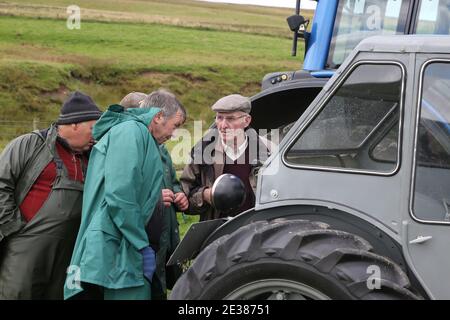 Muirkiirk, East Ayrshire, Schottland, Großbritannien, Village landwirtschaftliche Show, lokale Bauern und ihre Familien treffen und konkurrieren mit Vieh, Schafe & Rinder auf dem DisplayEine Gruppe von Bauern bewundern die Traktoren alt und neu Stockfoto