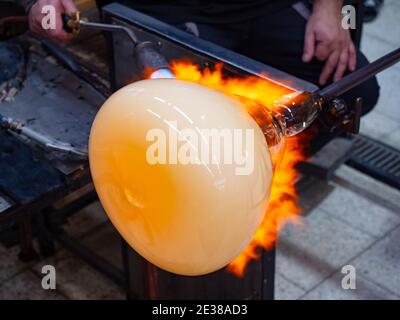 Glaskünstler formt das brennende Glas mit erhitzt es mit einer Gasbrenner-Taschenlampe. Nahaufnahme der Methode des Künstlers. Tschechische handgemachte Glas Studio. Stockfoto