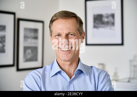 Lächelnder Mann im mittleren Alter von 50 Jahren, der zu Hause auf die Kamera schaut, Kopfbild. Stockfoto